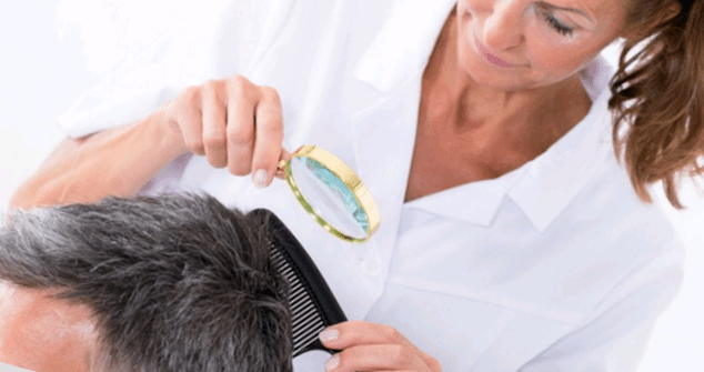 doctor examines psoriasis on the head